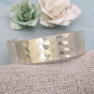 Silver-tone open cuff bracelet with a lightly hammered surface.