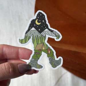 Bigfoot-shaped sticker filled with a mountain camping scene and a night sky.